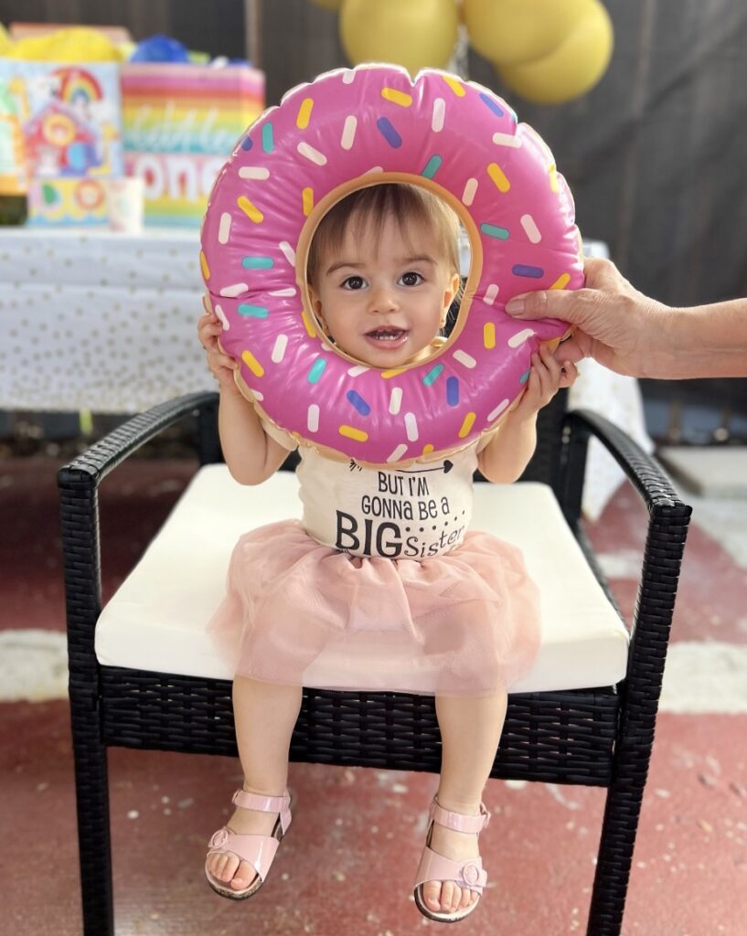 Photo of baby girl with donut at gender reveal