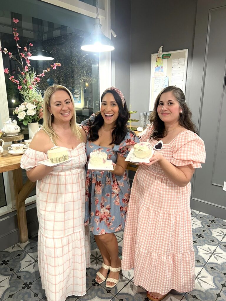 Photo of Influencers with cakes at Bubbles and Buttercream Galentines Event at New River Cafe and Bakery